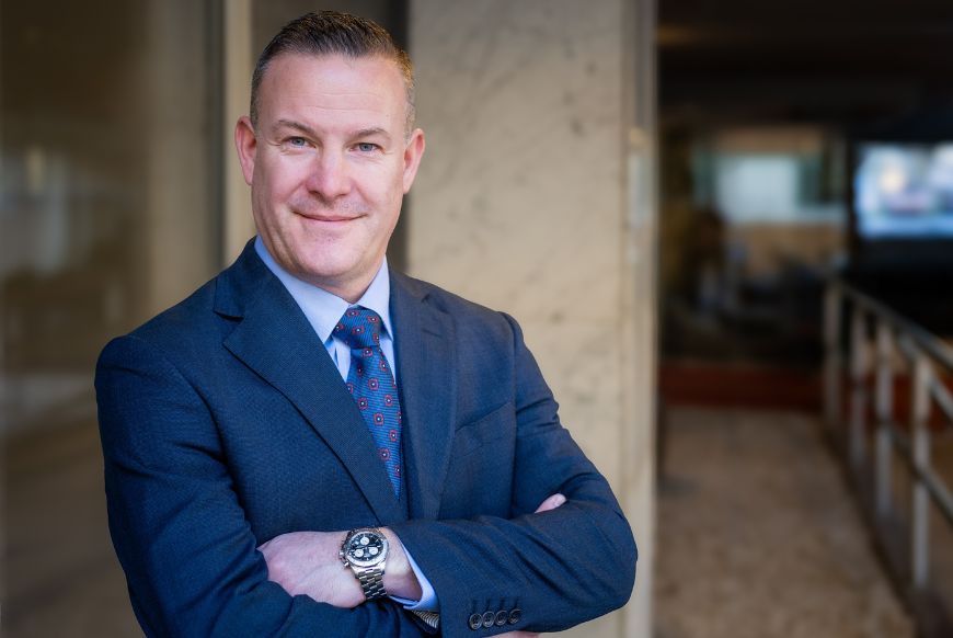 man in suit crossing his arms looking at camera